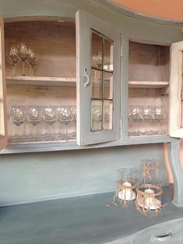 a cabinet with wine glasses in it with at Agriturismo Cascina Magana in Burago di Molgora