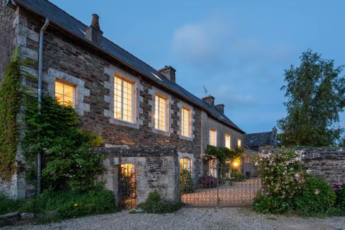 una vieja casa de ladrillo con sus luces encendidas en Ty Monde - Chambres d'hôtes en Finistère, en Poullaouen
