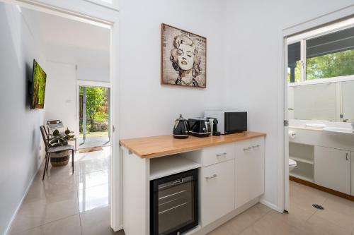 uma cozinha com armários brancos e uma bancada em URALLA STUDIO - South Coast - Private Guest Suite em Bomaderry