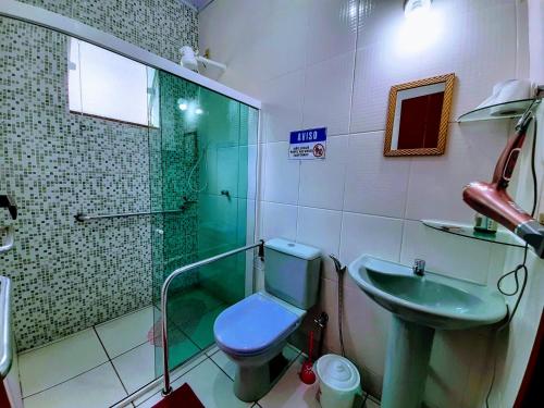 een badkamer met een toilet, een douche en een wastafel bij Casa Rosa Lumiar, Cachoeira Particular e Fazendinha in Lumiar