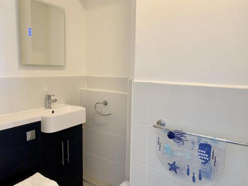 a white bathroom with a sink and a mirror at Seaclyffe Hotel Ltd in Llandudno