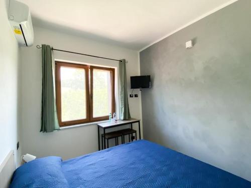 um quarto com uma cama azul e uma janela em B&b Monticella Contursi Terme em Contursi Terme