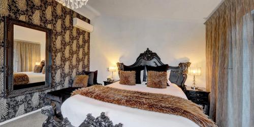 a bedroom with a large bed and a mirror at Orewa Beachcomber in Orewa