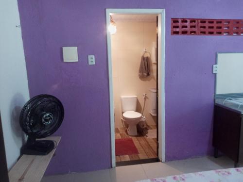 a purple bathroom with a toilet and a fan at Zen Villas - Chalés, Bem-Estar e Conexão com a Natureza in Lauro de Freitas