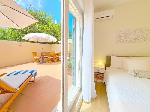 een slaapkamer met een bed en een patio met een parasol bij Villa Prana Guesthouse, Yoga & Ayurveda in Portimão