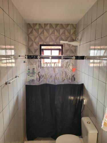 ein Bad mit WC und ein Schild, auf dem steht, warten Sie bis Sie hereinkommen in der Unterkunft Suítes Angra Sol e Mar in Angra dos Reis