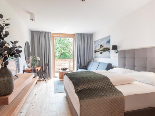 ein Schlafzimmer mit einem großen Bett und ein Wohnzimmer in der Unterkunft Belmonte Tirol - Boutique Hotel in Sillian