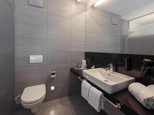 a bathroom with a sink and a toilet and a mirror at Belmonte Tirol - Boutique Hotel in Sillian