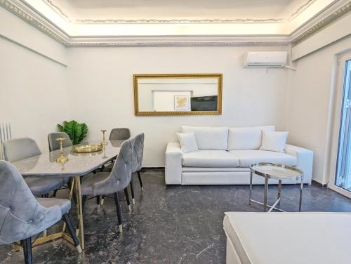 sala de estar con sofá blanco y mesa en Acropolis View Dream Apartments, en Atenas