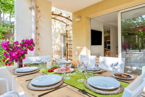 une table avec des assiettes et des verres au-dessus dans l'établissement BAO LOCATION - Ideal Pro & Groupe - Calme - Lumineux - WIFI - Terrasse - Jardin - Plage à 2km - Proche Centre Ville, Gare, Commerces - Parking Privé, à Toulon