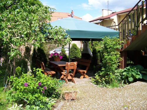 a patio with a table and a blue umbrella at Willa Jarzębinka in Międzyzdroje