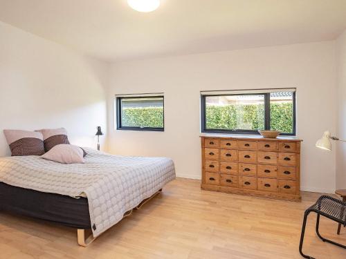 a bedroom with a bed and two windows and a dresser at 6 person holiday home in Væggerløse-By Traum in Væggerløse