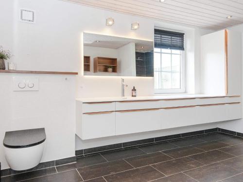 Baño blanco con aseo y lavamanos en Holiday home Thyborøn VI, en Thyborøn