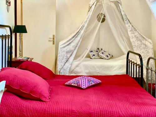 - une chambre avec un lit rouge à baldaquin dans l'établissement Charming Romantic Tower in Chateau Estate, à Ocquerre