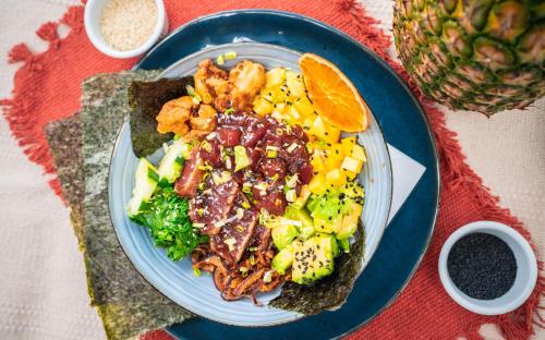 a plate of food with meat and vegetables on a table at Surf Synergy All-Inclusive Surf and Wellness Retreat in Jacó