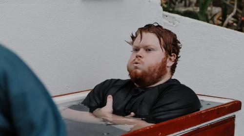 a man with a beard sitting in a bath tub at Surf Synergy All-Inclusive Surf and Wellness Retreat in Jacó