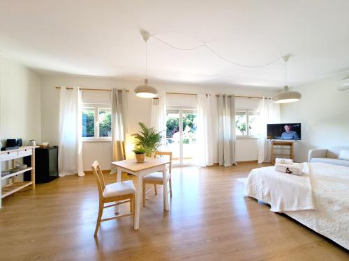 a living room with a bed and a table and chairs at Villa Prana Guesthouse, Yoga & Ayurveda in Portimão