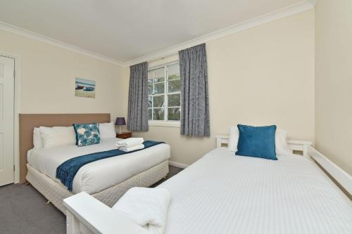 a bedroom with two beds and a window at Beggars Bridge Vineyard Homestead with pool and tennis in Rothbury