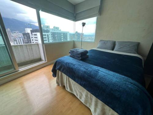 a bedroom with a bed with a blue blanket on it at #Amazing suite in the heart of Quito…. La carolina 3A in Quito
