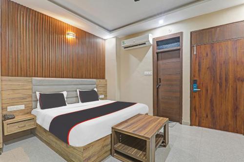a bedroom with a large bed and a wooden door at Collection O The Crestelia in Lucknow