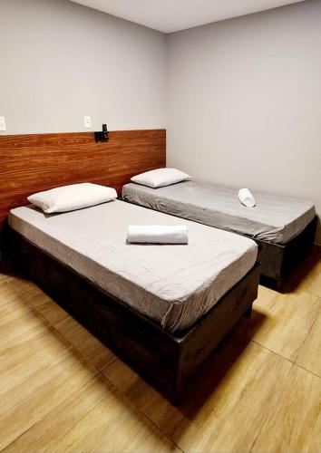 two twin beds in a room with at Hotel Platina in Juiz de Fora