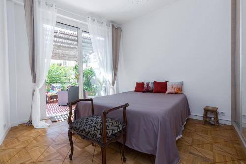 une chambre avec un lit avec une chaise et une fenêtre dans l'établissement Appart Nice Centre - Terrasse privé Exceptionnelle - Supérieur 3 pièces AC - Garage privé, à Nice
