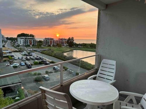 a balcony with a table and chairs and a view of a city at Seaview, Beach, Sunsets, Nature in Heiligenhafen