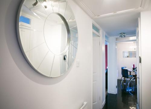a round mirror on a wall in a hallway at So-Cute Cityside in Belfast