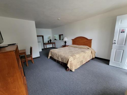 a bedroom with a bed and a dresser and a desk at Stellar Motel in Port Orchard