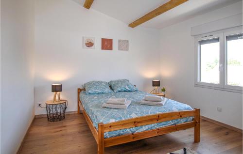 - une chambre avec un lit avec des draps bleus et deux lampes dans l'établissement 4 Bedroom Lovely Home In Clon D Andran, à Cléon-dʼAndran