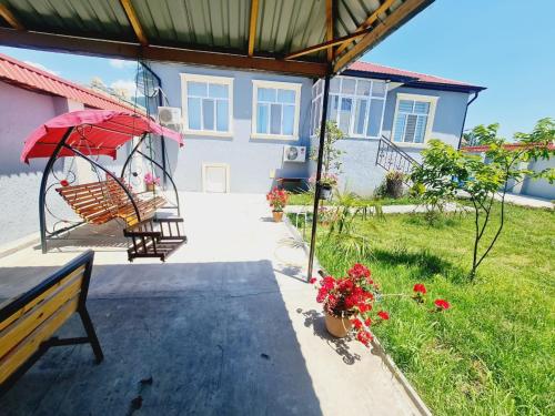 a patio with a bench and an umbrella at Qebele Resot home in Gabala