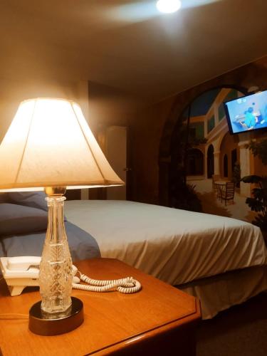uma lâmpada sobre uma mesa ao lado de uma cama em Seven and Seven B&B em La Paz
