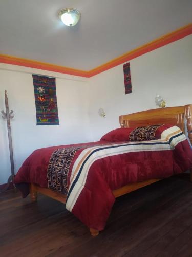 um quarto com uma cama grande e um edredão vermelho em Seven and Seven B&B em La Paz