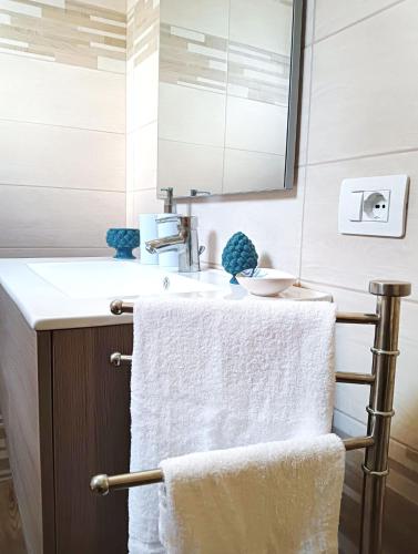 a bathroom with a towel rack and a sink at Loiacono Apartments 2 in Caria
