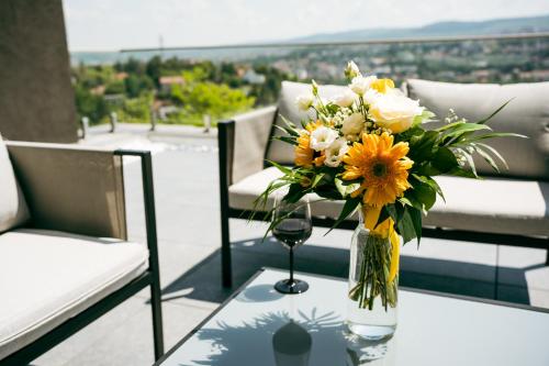 a vase of flowers on a table on a balcony at Evo Residence Panoramic in Cluj-Napoca