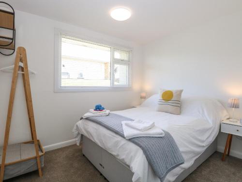 a bedroom with a bed and a ladder and a window at Dolly's Lookout in Lowestoft