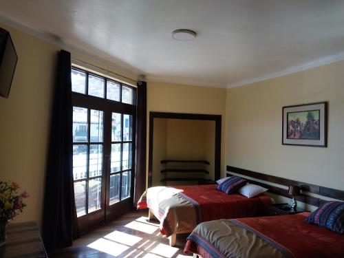 a bedroom with two beds and a window at Hospedaje Balcón Cusqueño in Cusco