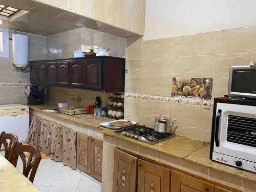 a kitchen with a stove and a microwave at Grand appartement 1 chambre in Tangier