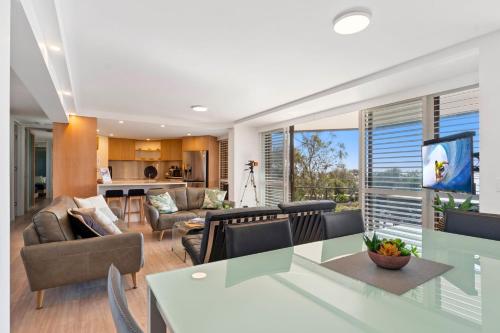 a kitchen and living room with a table and chairs at Spectacular Location and Views, 3 Bedrooms , Private Rooftop Spa in Mooloolaba
