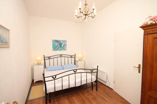 a bedroom with a bed and a chandelier at Apartments by the sea Opatija - Volosko, Opatija - 7846 in Volosko