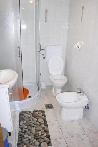 a bathroom with a toilet and a shower and a sink at Apartments by the sea Valun, Cres - 8081 in Valun