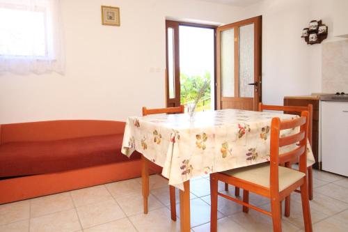 a kitchen with a table with a table cloth on it at Apartments by the sea Valun, Cres - 8081 in Valun