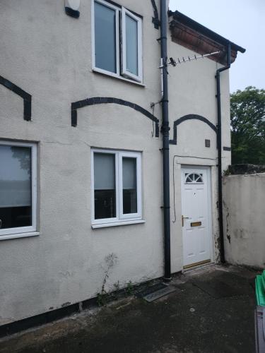 a white house with a white door and windows at Woodborough road close to city in Nottingham