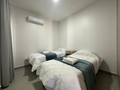 three beds in a room with white walls at Domum 144 2 in San Juan