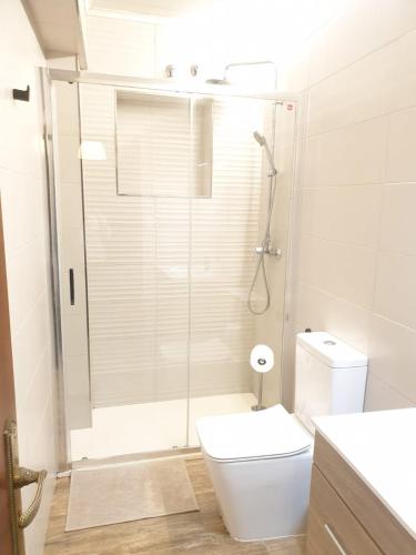 een witte badkamer met een douche en een toilet bij Apartamento en el corazón de Vilagarcía in Vilagarcia de Arousa