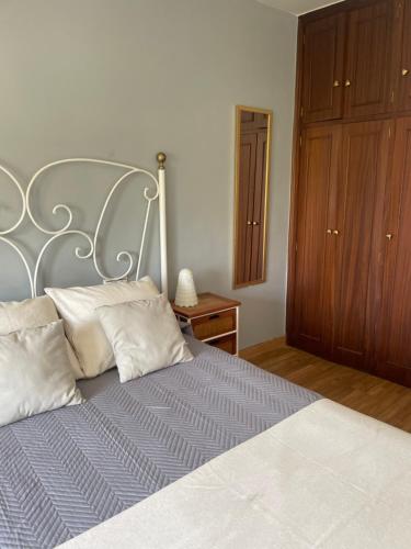 een slaapkamer met een groot bed met een metalen hoofdeinde bij Apartamento en el corazón de Vilagarcía in Vilagarcia de Arousa