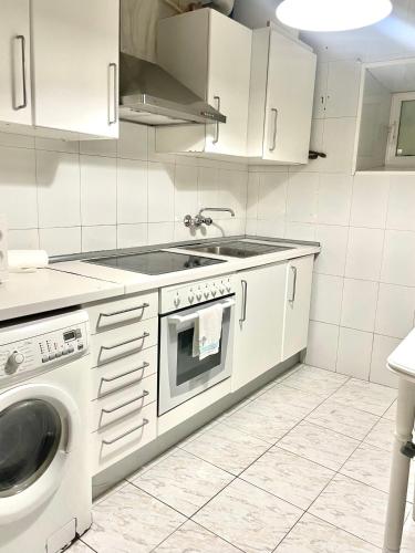 een witte keuken met een wastafel en een wasmachine bij Apartamento en el corazón de Vilagarcía in Vilagarcia de Arousa