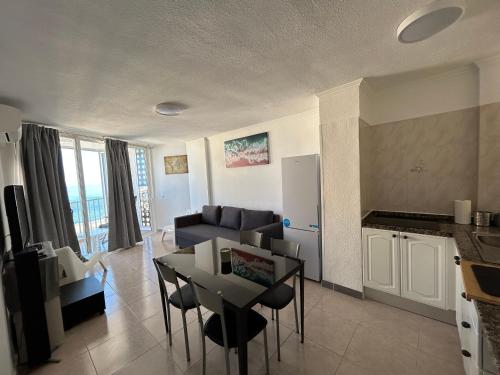 een keuken en een woonkamer met een tafel en een bank bij Atlantic Sunset Floor - Las Americas in Playa de las Americas