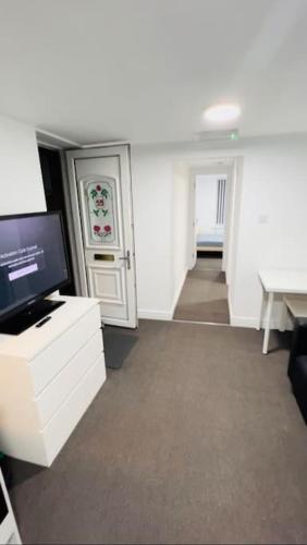 a living room with a tv and a desk with a computer at Cosy Apartment Next To City Centre in Sheffield