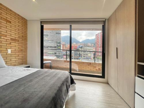 a bedroom with a bed and a large window at Hermosa Vista en Chapinero cómodo wifi in Bogotá